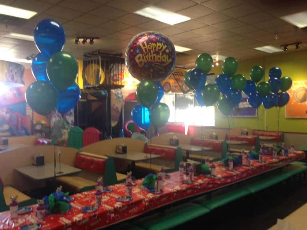Colorful birthday balloon bouquets above a party table