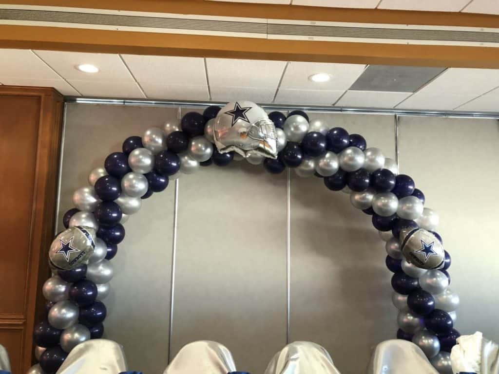 Black and silver balloon arch with a star-shaped balloon at the top