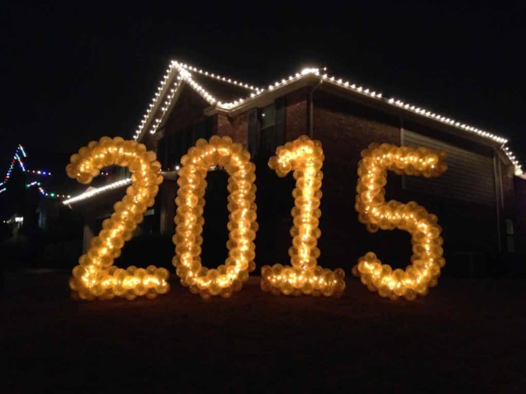 Gold balloon numbers 2015 displayed outside a house at night