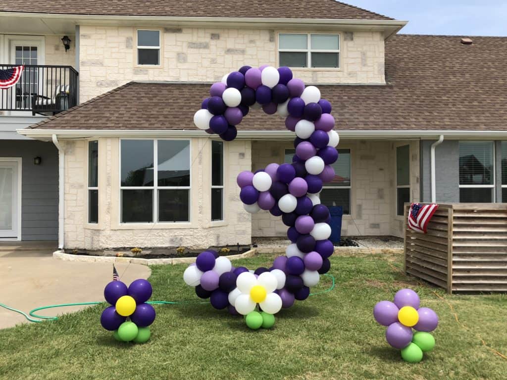 Purple and white balloon number 3 with balloon flowers on a lawn