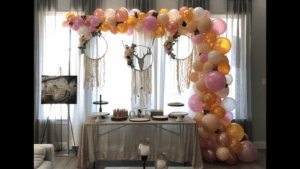 a table with balloons and a cake